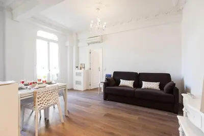 a living room with a couch and a table at Appartements Massena in Nice