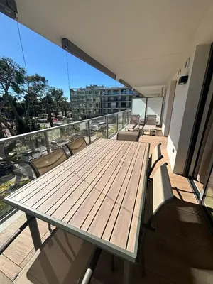 a deck with a table and chairs on a balcony at L'Odyssée in Saint-Laurent-du-Var