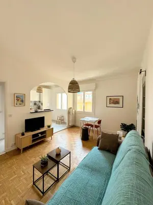 a living room with a blue couch and a table at Charmant studio près de la plage et la Promenade des Anglais in Nice