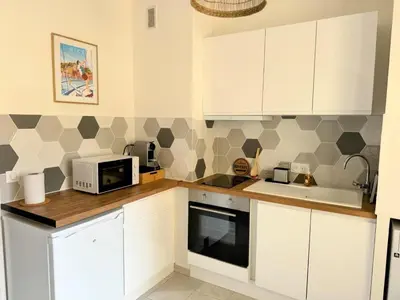 a kitchen with white cabinets and a microwave at Charmant studio près de la plage et la Promenade des Anglais in Nice