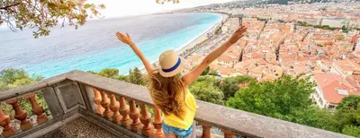 a woman standing on a balcony with her arms in the air at Place Massena - Small Peaceful Haven in Nice