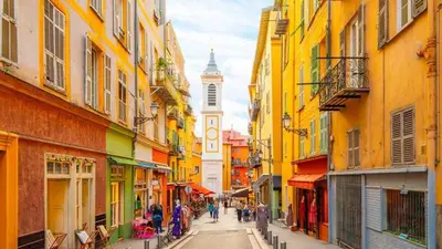 a city street with a clock tower in the distance at Place Massena - Small Peaceful Haven in Nice