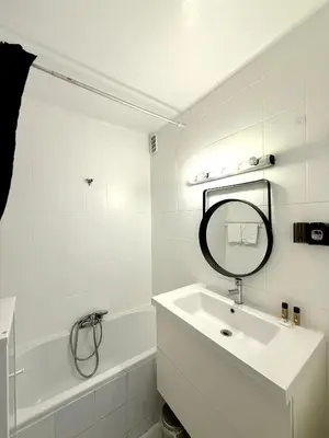 a white bathroom with a sink and a mirror at Charmant appartement 3 pièces au cœur de Nice in Nice
