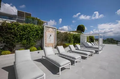 a row of white chairs sitting on a patio at Le 120 m2 - luxe, piscine, terrasse et garage in Nice