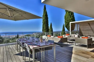 a patio with a table with wine glasses on it at Le 120 m2 - luxe, piscine, terrasse et garage in Nice