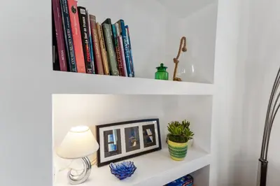 a shelf with books and a lamp on a desk at Le Garibaldi - City centre - Bright - AC in Nice