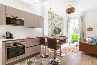 a kitchen with a table and a dining room at New Cosy Apartment Libération in Nice