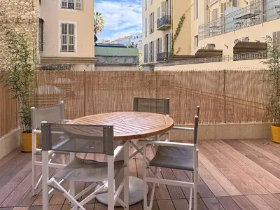 a wooden table and chairs on a balcony at Charmant 2P neuf avec terrasse, proche mer in Nice