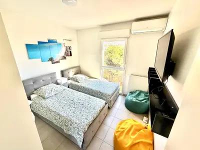 a living room with a bed with yellow pillows at Appartement 3 pièces avec parking a Nice Chez David in Nice
