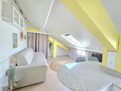 a living room with a white couch and a table at Cosy sous les toits - Nice Gare - 2 pers in Nice