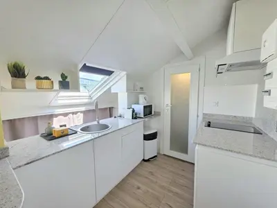 a white kitchen with white cabinets and a sink at Cosy sous les toits - Nice Gare - 2 pers in Nice