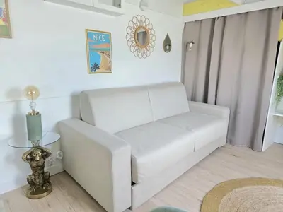 a white couch in a living room with a table at Cosy sous les toits - Nice Gare - 2 pers in Nice