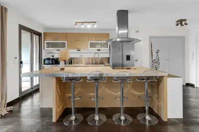 a kitchen with a large island with bar stools at Havre de Paix Mont Boron Proche du Port in Nice