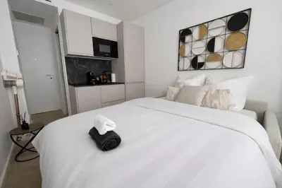 a white bed with a black bag on it at Studio sur la promenade des anglais in Nice