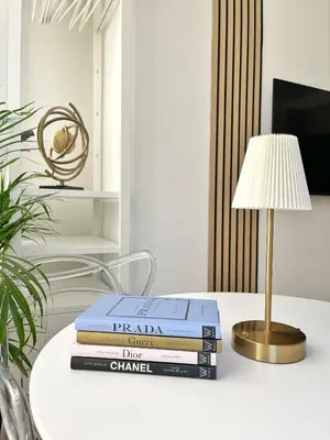 a stack of books on a table with a lamp at Studio sur la promenade des anglais in Nice