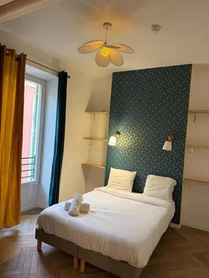 a bedroom with a bed with a green wall at MOON 24 - Appartement Nice 6P in Nice