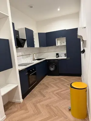 a kitchen with blue cabinets and a yellow stool at MOON 24 - Appartement Nice 6P in Nice