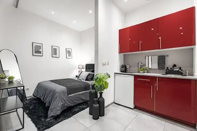 a bedroom with a bed and a kitchen with red cabinets at Nice Renting - GALLO - New Modern Loft Old Town Massena in Nice