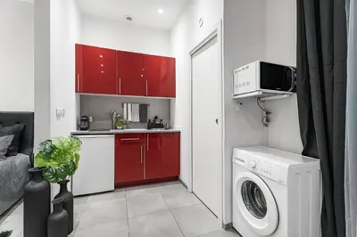 a kitchen with red cabinets and a washing machine at Nice Renting - GALLO - New Modern Loft Old Town Massena in Nice