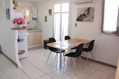 a kitchen and dining room with a table and chairs at Le Cocon Niçois Studio Cozy et Lumineux avec Parking in Nice