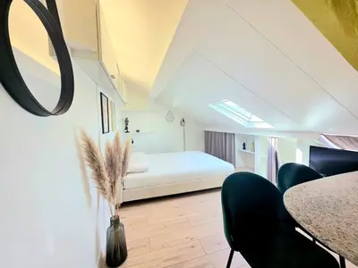 a bedroom with a bed and a table and chairs at Mansarde Lumineuse - Nice Gare 2 pers in Nice
