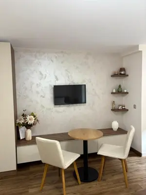 a dining room with a table and chairs and a tv at Perle au Port de NICE in Nice