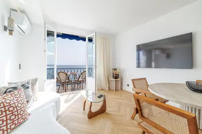 a living room with a table and a view of the ocean at Outstanding View on the Promenade - Awesome 2 Bdr in Nice