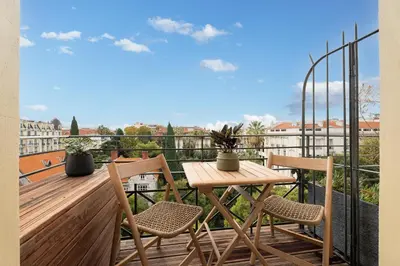 a wooden table and chairs on a balcony with a view at Nice Renting - HUGO - Luxury Honeymoon Suite Terrace Park View Free Parking in Nice