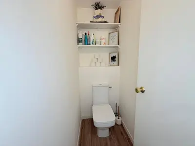 a small bathroom with a toilet and shelves at Spacieux 3 pièces Gambetta, proche Tramway in Nice
