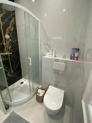 a white bathroom with a shower and a toilet at Zgondoiu Résidence in Nice