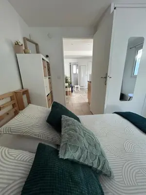 a bedroom with a bed with two pillows on it at Two rooms with 30 m2 garden in villa in Cagnes-sur-Mer