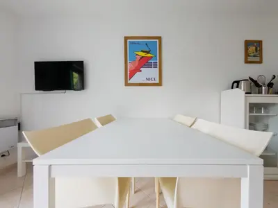 a white dining room table with two chairs and a tv at Le Soleil D'or 4 Pers Parking WiFi in Nice