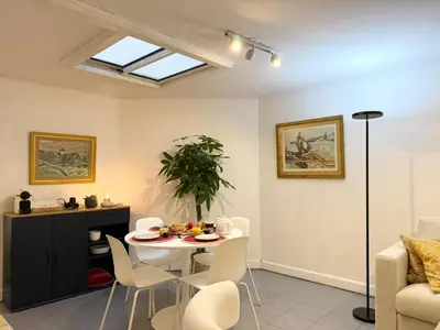 a living room with a table and chairs at Appartement à 100 m de la mer avec stationnement gratuit in Nice