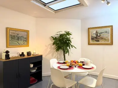 a dining room with a white table and white chairs at Appartement à 100 m de la mer avec stationnement gratuit in Nice