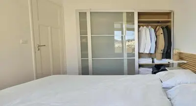a bedroom with a white bed and a closet at Le grand Escurial in Nice
