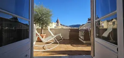 two white chairs sitting on a patio outside a door at Le grand Escurial in Nice