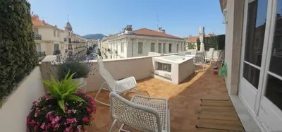a balcony with chairs and a stove on a building at Le grand Escurial in Nice