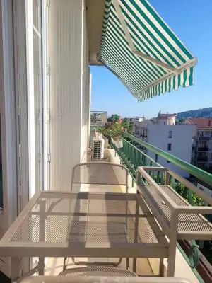 a balcony with two chairs and an umbrella at Apartment nice view in Nice