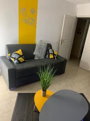 a living room with a couch and a table at Studio 27m2 en résidence standing piscine in Nice