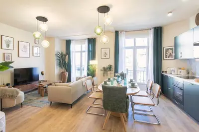 a kitchen and living room with a table and chairs at L10 Suite Clemenceau Central, next train station in Nice