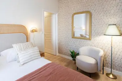 a bedroom with a bed and a mirror and a chair at L10 Suite Clemenceau Central, next train station in Nice