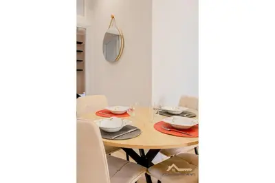 a dining room table with a mirror on the wall at Nice acropolis 3 pièces proche du centre in Nice