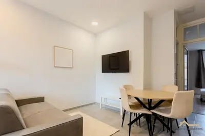 a living room with a table and a couch at Nice Tête au carré 3 pièces proche coulée verte in Nice