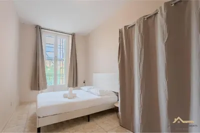 a small bedroom with a bed and a window at Nice Tête au carré 3 pièces proche coulée verte in Nice