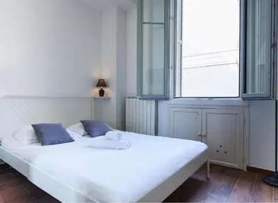 a white bed in a room with a window at Modern & Central Apartment in Nice