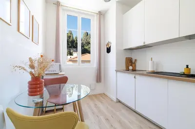 a kitchen with a glass table and a window at Cozy and bright appartement - Port of Nice in Nice