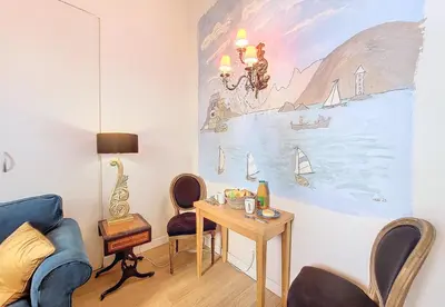 a living room with a table and a painting on the wall at Nestor&Jeeves - PALAIS ALICE - Central - Near Beach in Nice
