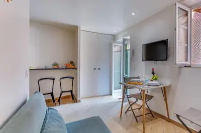 a living room with a table and chairs and a tv at ESCAPADE AP4463 By Riviera Holiday Homes in Villefranche-sur-Mer