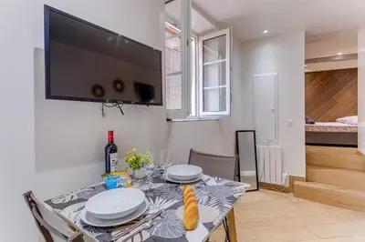 a dining room with a table with a television on the wall at ESCAPADE AP4463 By Riviera Holiday Homes in Villefranche-sur-Mer