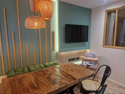 a dining room with a wooden table and a television at PASTO DROITE Appartement Nice 6P in Nice